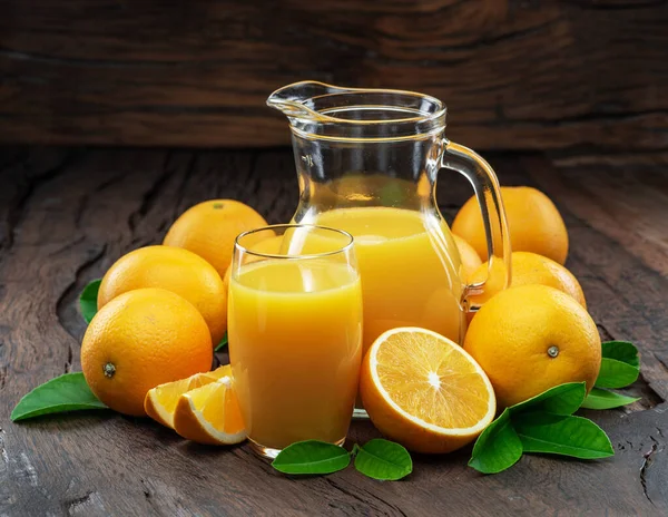 Gelbe Orangenfrüchte Und Frischer Orangensaft Isoliert Auf Dunklem Holzgrund — Stockfoto