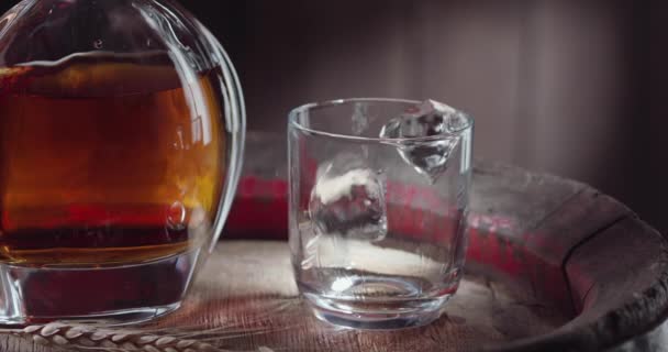 Isbit Faller Sakta Ner Ett Glas Whisky Ovanpå Gammal Whiskytunna — Stockvideo