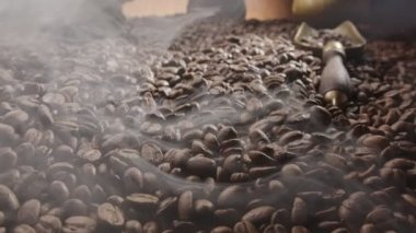 Kahve çekirdekleri biraz kızarmış dumanla kızartılır, kamera yavaşça sayısız kahve çekirdeklerini takip eder.. 