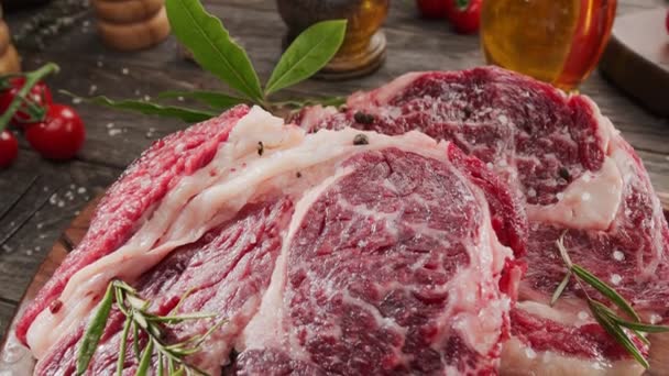 Twee Rauwe Rib Oogsteaks Met Specerijen Kruiden Een Houten Keukentafel — Stockvideo