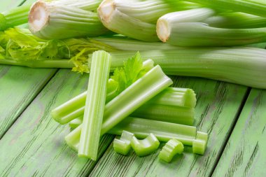 Yeşil ahşap masada bir yığın kereviz kaburgası. Sağlıklı gıda geçmişi.