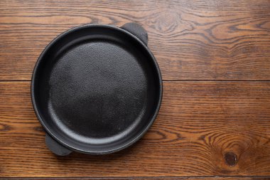 Ahşap arka planda boş tava. Üst görünüm.