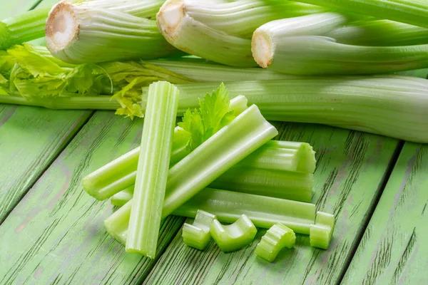 Yeşil ahşap masada bir yığın kereviz kaburgası. Sağlıklı gıda geçmişi.