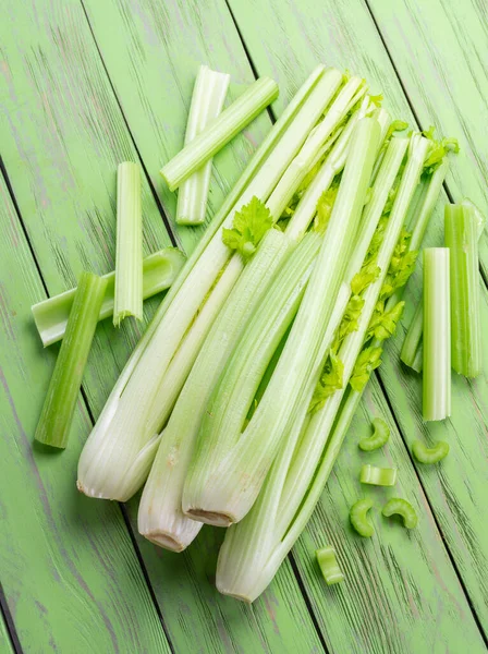 Yeşil ahşap masada bir yığın kereviz kaburgası. Sağlıklı gıda geçmişi.