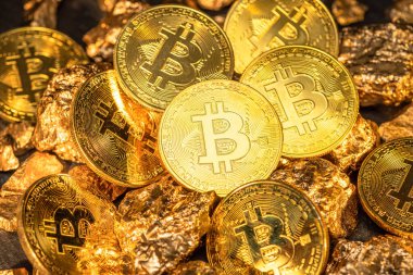 Bitcoins ve altın parçaları yakın plan. Bitcoin altına karşı, hangisi daha çekici??