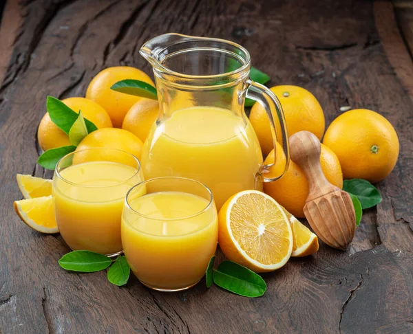 Gelbe Orangenfrüchte Und Frischer Orangensaft Isoliert Auf Dunklem Holzgrund — Stockfoto