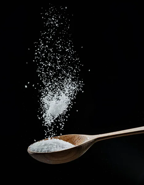 White Refined Sugar Crystals Falling Wooden Spoon Black Background — Fotografia de Stock