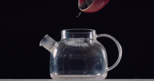茶叶从碗中倒入玻璃杯茶壶 黑色背景的背面 慢动作 — 图库视频影像