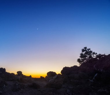 Gün batımında kayalık alanın silueti. Günbatımı gökyüzünün renkleri. Güneş kaybolduktan sonra gökyüzünün renkli bir parçası