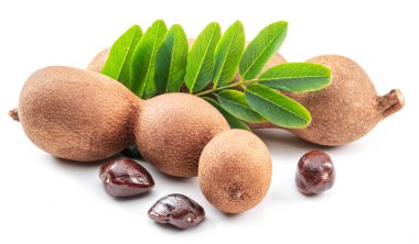 Olgun demirhindi meyvesi, yapraklar ve beyaz arka planda izole edilmiş demirhindi tohumları..