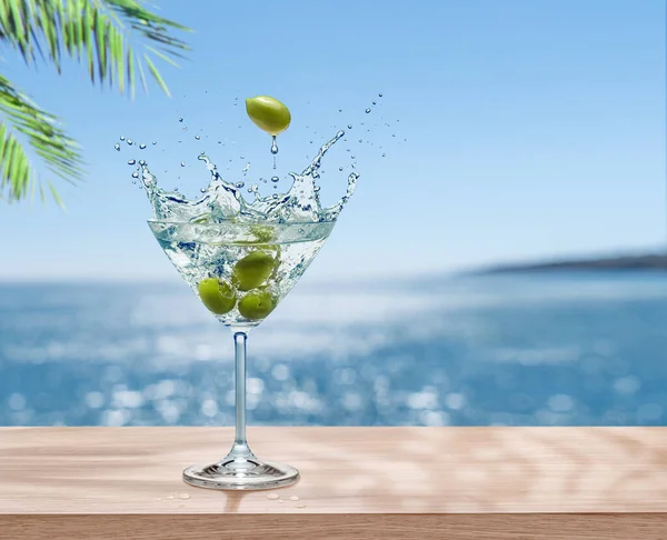 Martini Glass Olives Beverage Splash Table Top Blurred Sparkling Sea —  Fotos de Stock