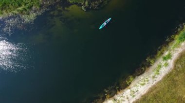 Top aerial view of a group of tourists sailing on a summer river on kayaks. River Seym, Ukraine