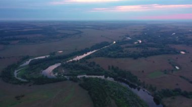 Beautiful aerial view video from a drone of Ukrainian nature - Seim river, morning sun in the mist on the river with trees and open spaces.