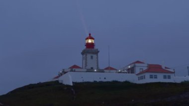 Portekiz 'in Cabo Da Roca Burnu' ndaki Atlantik Okyanusu 'nda farol deniz feneriyle güzel bir karanlık akşam manzarası. 2022 Eylül 'ünde Avrupa' nın en batı noktası..