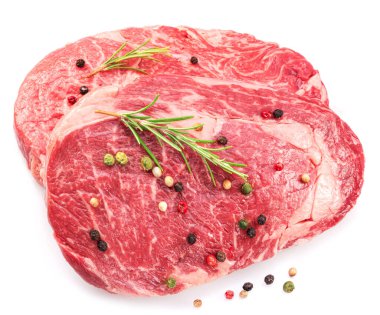 Beyaz arka planda biberiyeli ve biberiyeli çiğ biftek. Üst görünüm. 