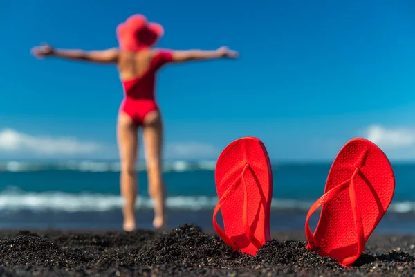 Röda Flip Flops Svart Sand Och Silhuett Kvinna Röd Baddräkt — Stockfoto