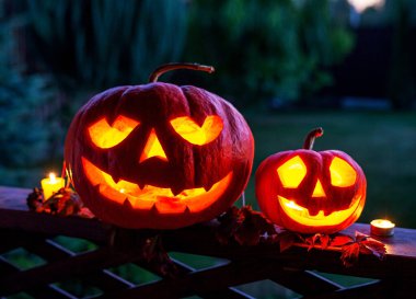 Cadılar Bayramı için balkabağı oyulmuş balkabağı. Gizemli orman arka planındaki kötü ruhların korunması için korkutucu gülümsemeleri olan balkabağı.. 