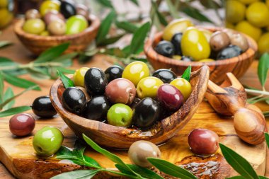 Kalamata, ahşap kasede yeşil ve siyah zeytin. Gıda arkaplanı.