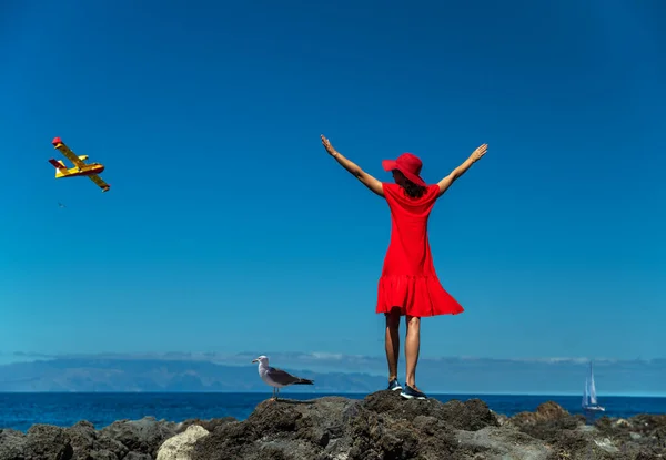 Ευτυχισμένη Γυναίκα Κόκκινα Στέκεται Στη Βραχώδη Ακτή Του Ωκεανού Ανοιχτά — Φωτογραφία Αρχείου