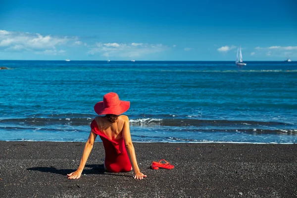 黒海の砂浜で赤い水着の女性 背景には穏やかな海と真っ青な空 — ストック写真