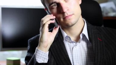 Genç adam cep telefonuyla konuşuyor.