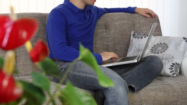 Young man, student working with a laptop at home — Stock Video