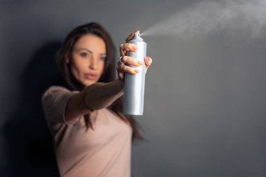 Gri arka planda izole edilmiş uzun saçlı, iyimser esmer kadının tam boy profil fotoğrafı.