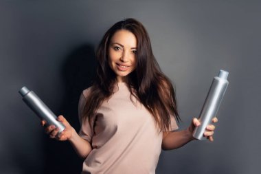 Gri arka planda izole edilmiş uzun saçlı, iyimser esmer kadının tam boy profil fotoğrafı.