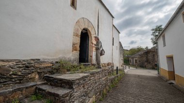 Santiago 'da Camino' da kilisede şapkası, çantası ve bastonu olan bir seyyah. St. James 'in Yolu