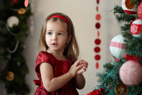 Mädchen in der Nähe von Weihnachtsbaum lizenzfreie Stockfotos