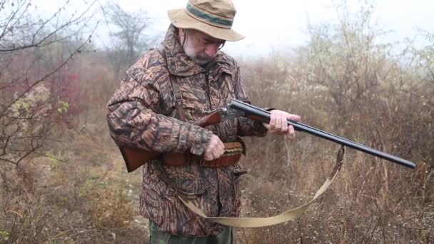 身穿猎服 留着灰胡子 装上双管来复枪子弹 做成瞄准线 — 图库视频影像