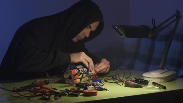 Человек Черной Толстовке Темной Комнате Паивает Собирает Бомбу Динамита Телефоном — стоковое видео