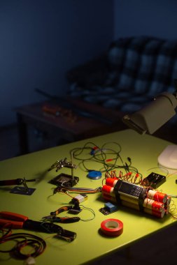 Bomba yapma aracı ve bomba lambanın ışığında masanın üzerinde.