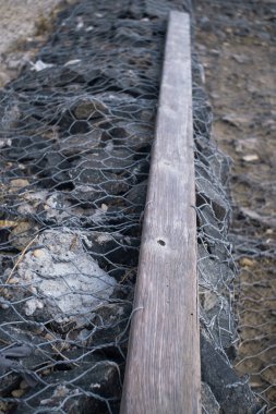 Metal şebeke ve granit taşlardan yapılan kıyı güçlendirme