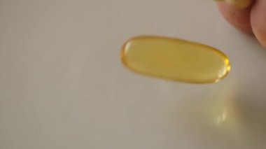 Düşen haplar ve kapsüller yavaş çekimde ışık yüzeyine düşüyor.