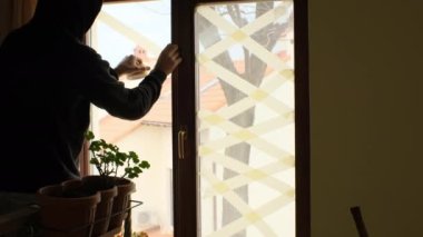 Ukrayna 'daki savaş sırasında parçaların patlamasını önlemek için pencerelere yapıştırıcı bandı yapıştırdım.