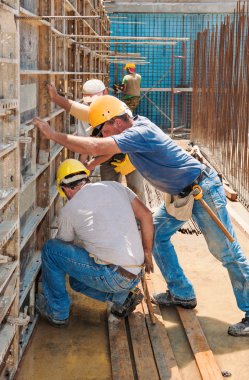 Construction builders positioning concrete formwork frames clipart