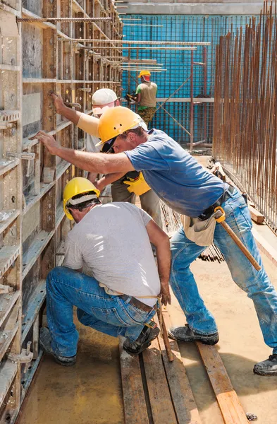 Construtores de construção posicionamento de estruturas de cofragem de concreto — Fotografia de Stock