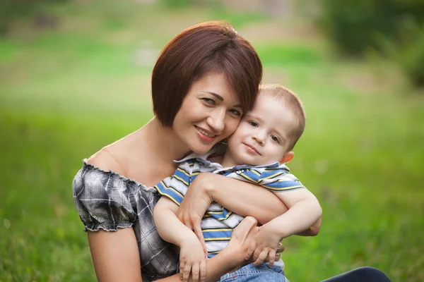 Glad liten pojke i parken med mamma — Stockfoto