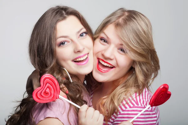 Two girlfriends teens with candy hearts — Stock Photo, Image