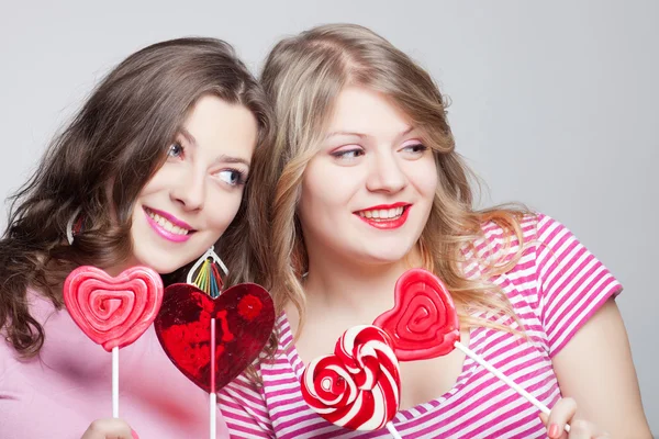 Two girlfriends teens with candy hearts — Stock Photo, Image