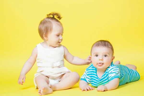 Dvě děti, plazení, izolované na žluté — Stock fotografie