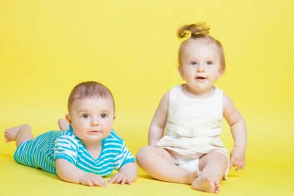 Two kids crawling, isolated on yellow — Stock Photo, Image