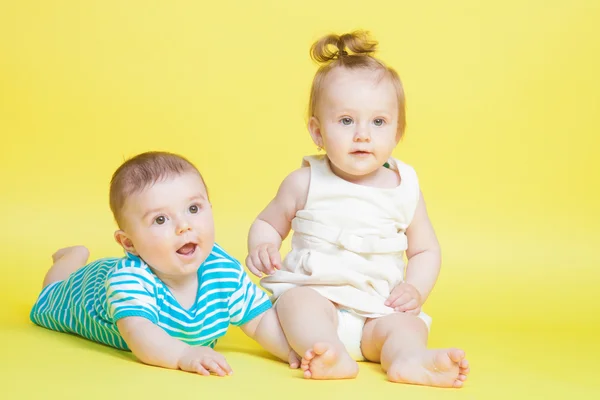 Two kids crawling, isolated on yellow — Stock Photo, Image