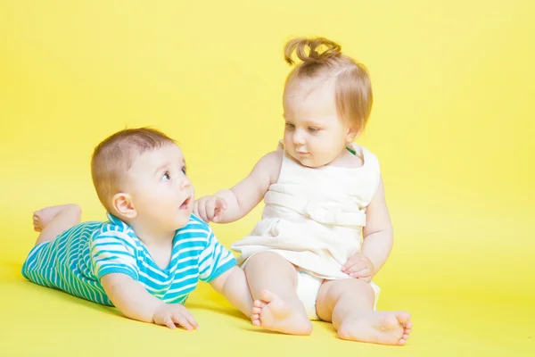 Two kids crawling, isolated on yellow — Stock Photo, Image