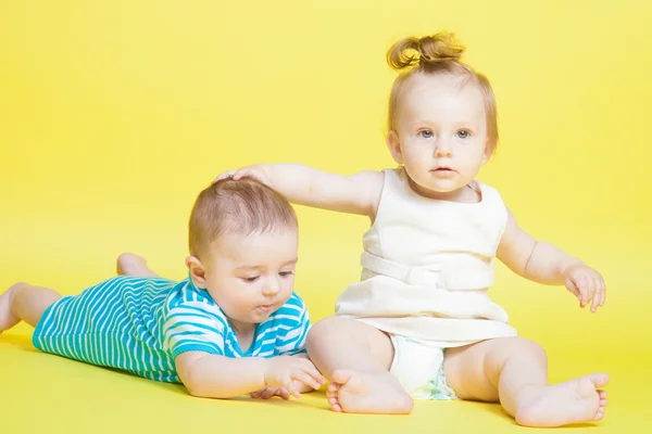 Two kids crawling, isolated on yellow — Stock Photo, Image