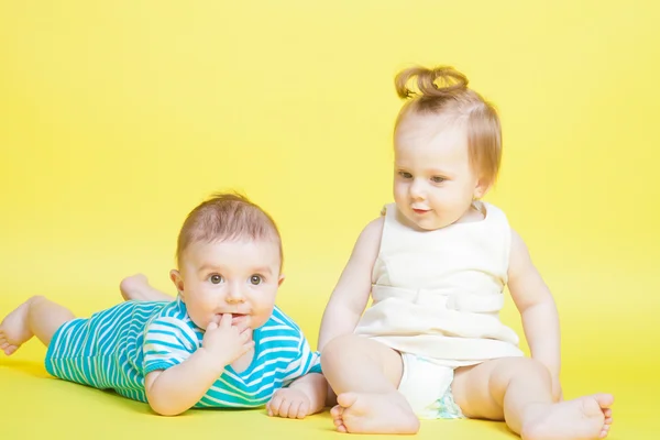 Two kids crawling, isolated on yellow — Stock Photo, Image