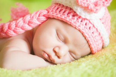 şeritli bir şapka giymiş güzel uyuyan bebek