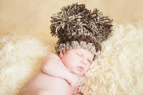 Belo bebê adormecido usando um chapéu listrado — Fotografia de Stock