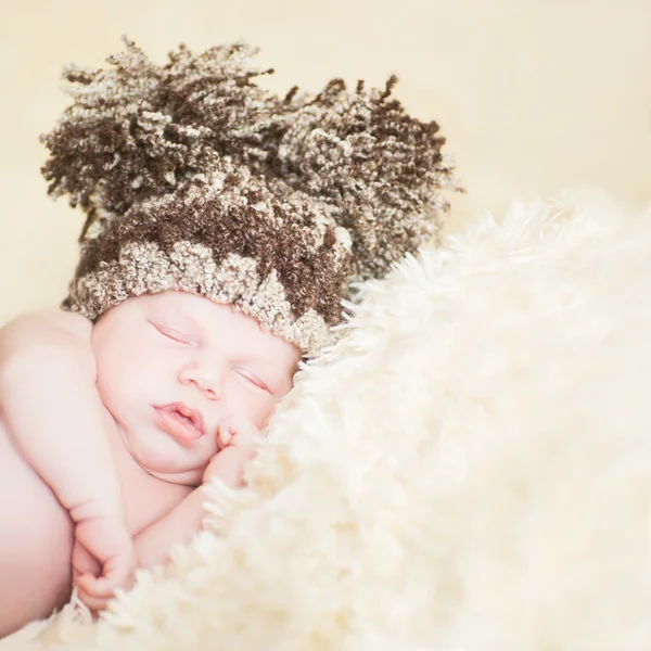 Belo bebê adormecido usando um chapéu listrado — Fotografia de Stock